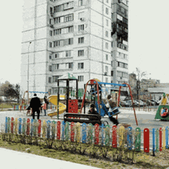Kinder auf einem Spielplatz vor einem Hochhaus, in das eine Drohne eingeschlagen ist