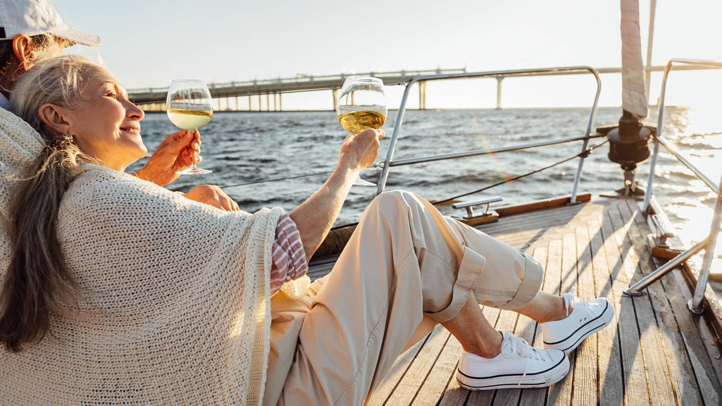 Ein Paar in Rente trinkt Sekt auf einer Jacht (Symbolbild)