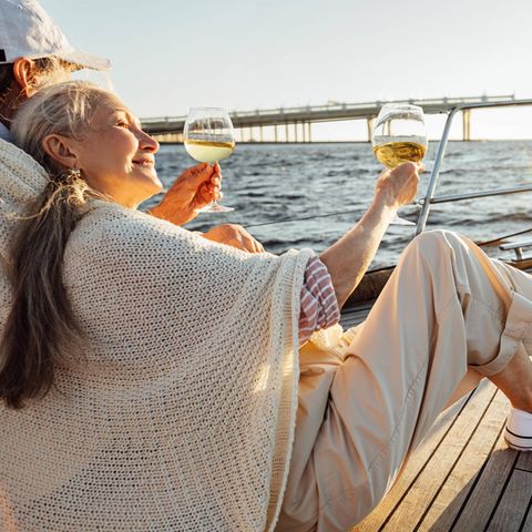 Ein Paar in Rente trinkt Sekt auf einer Jacht (Symbolbild)