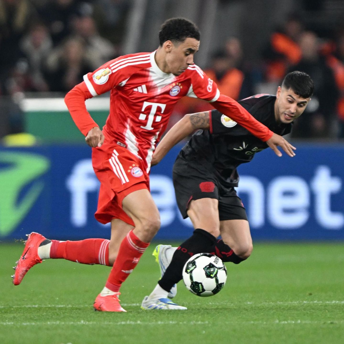 Jamal Musiala (l.) vom FC Bayern im Zweikampf mit Leverkusens Exequiel Palacios