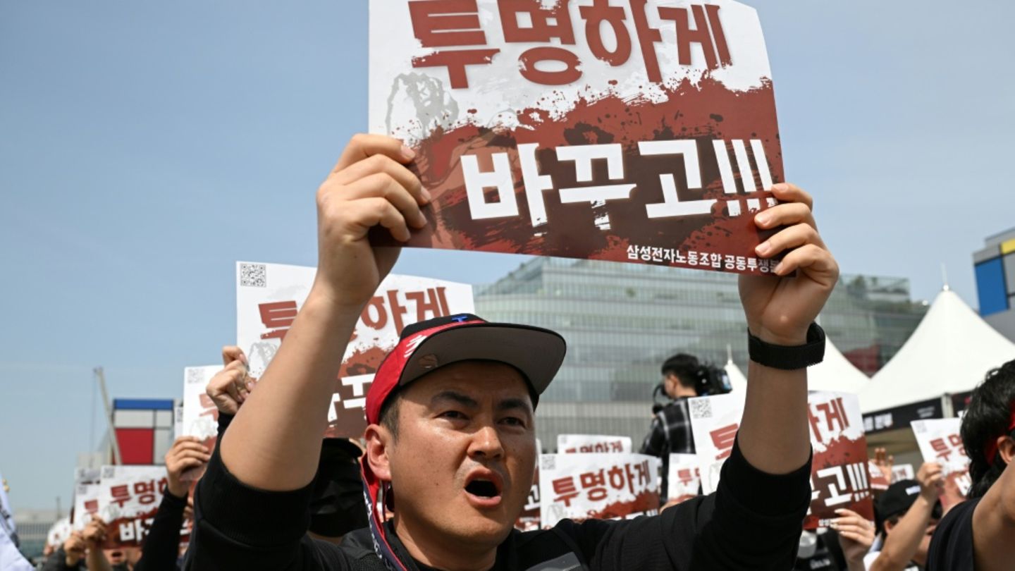Members of the Samsung Electronics labour union hold signs reading "Change it to be transparent!" as they stage a mass rally dem