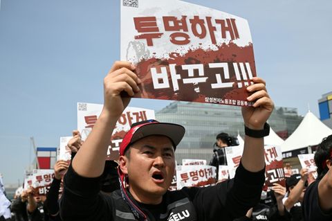 Members of the Samsung Electronics labour union hold signs reading "Change it to be transparent!" as they stage a mass rally dem