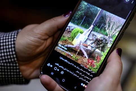 Frau schaut auf Handy Jesus-Beschädigung