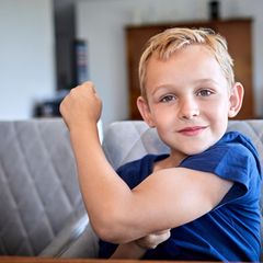 Ein Junge zeigt seinen Bizeps