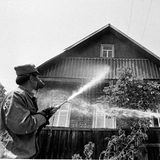 Männer dekontaminieren ein Haus mit Wasser