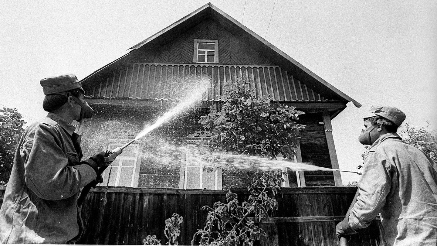 Männer dekontaminieren ein Haus mit Wasser