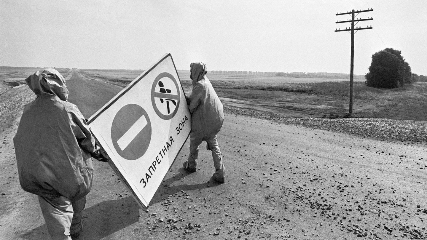 Menschen stellen Warnschilder in der Sperrzone auf
