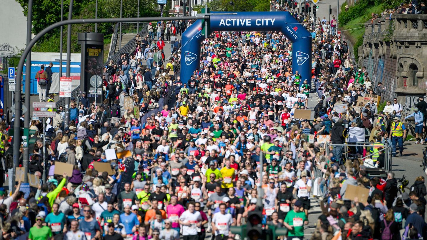 Teilnehmer laufen an den Landungsbrücken vorbei. Foto: Gregor Fischer/dpa
