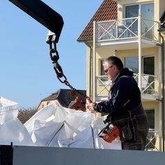 Unternehmer Fred Babbel lädt mit Sand gefüllte Big Bags von einem Lkw am Hafen von Kirchdorf ab