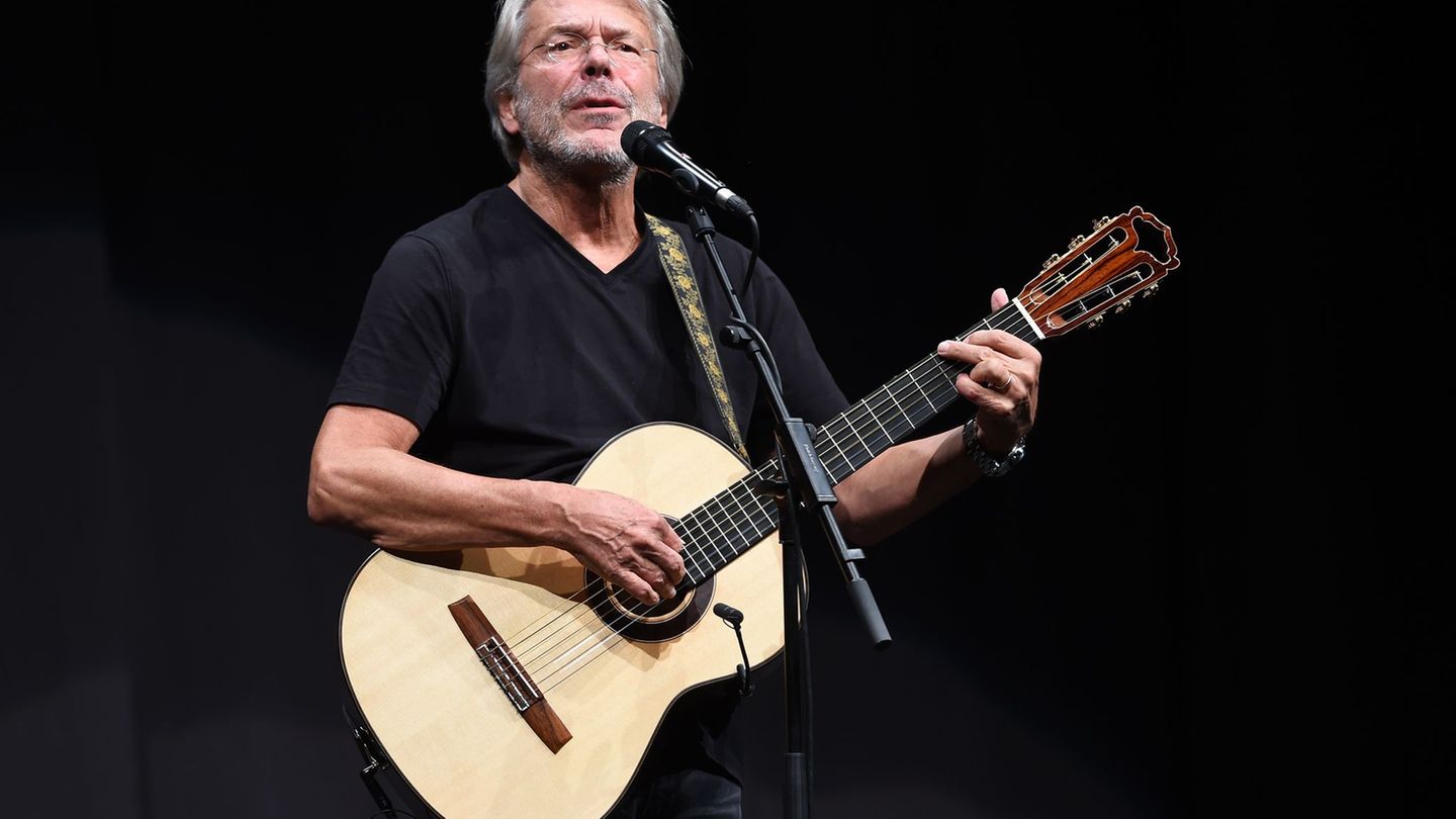 So kennen die Fans Reinhard Mey seit Jahrzehnten: Mit Gitarre auf der Bühne. (Archivbild) Foto: Swen Pförtner/dpa