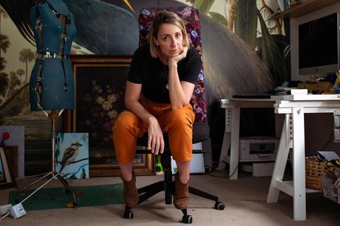 Candice Fox auf einem Bürostuhl umgeben Bildern, einem Schreibtisch und einer Schneiderpuppe