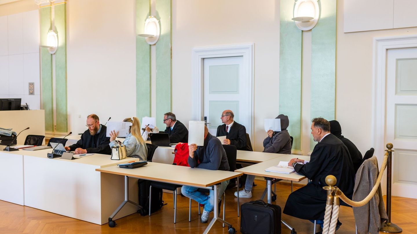 Drei Männer und zwei Frauen sitzen mit ihren Anwälten auf der Anklagebank. Foto: Philipp von Ditfurth/dpa