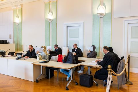 Drei Männer und zwei Frauen sitzen mit ihren Anwälten auf der Anklagebank. Foto: Philipp von Ditfurth/dpa