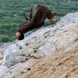Reg-e-Rawan, Afghanistan. Ein Jugendlicher vollführt einen Rückwärtssalto einen steilen, sandigen Berghang hinunter. Jedes Wochenende reisen Hunderte Besucher nach Reg-e-Rawan – was auf Dari „die wandernden Sande“ bedeutet –, um dort Parkour zu praktizieren, den honigfarbenen Sand der Provinz Kapisa hinunterzurollen und sich vor atemberaubender Kulisse zu entspannen.