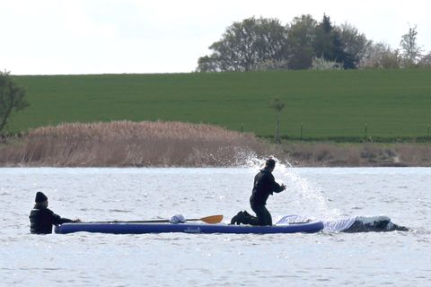Helfer spritzen Wasser auf den gestrandeten Wal vor der Insel Poel