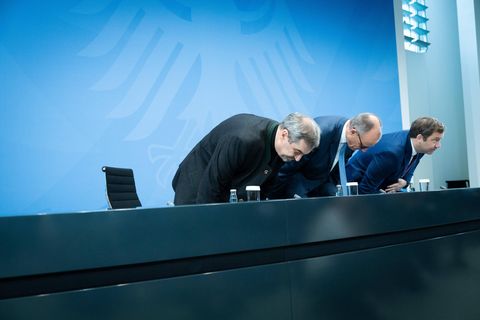 Markus Söder, Friedrich Merz und Lars Klingbeil setzen sich auf Stühle