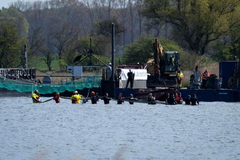 Helfer versuchen den gestrandeten Wal aus dem flachen Wasser zu einem Transportschiff zu ziehen, das in der Fahrrinne wartet. Fo