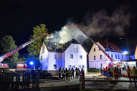 Einsatzkräfte der Feuerwehr sind mit einer Drehleiter am Brand eines Dachstuhls in Nürnberg beschäftigt. Foto: David Oßwald/NEWS