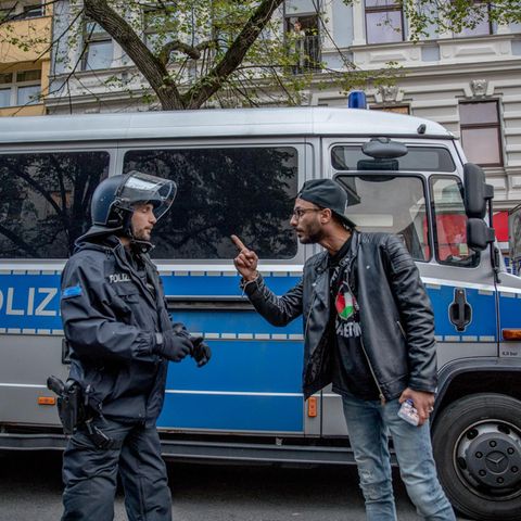 Ein Mann diskutiert mit einem Polzisten