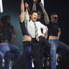 Harry Styles performt in einem Anzug auf der Bühne