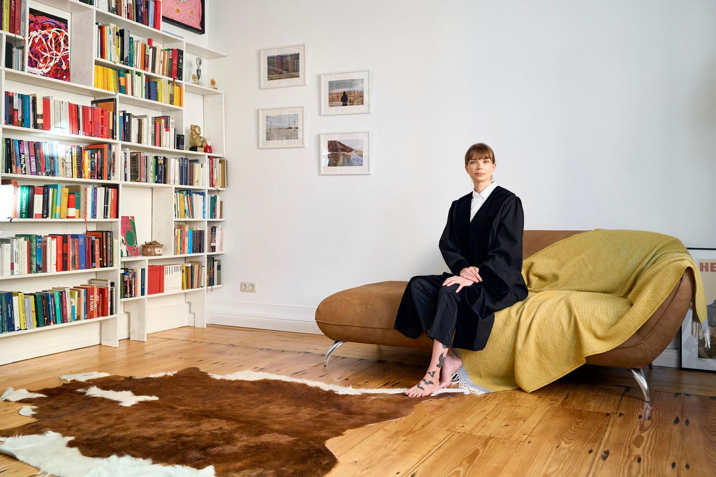 Ein Porträt von einer Frau, in "Uniform", die auf einem Sofa zuhause sitzt