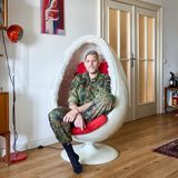 Ein Porträt von einer Transfrau in Bundeswehr Uniform, sitzt in einer Wohnung