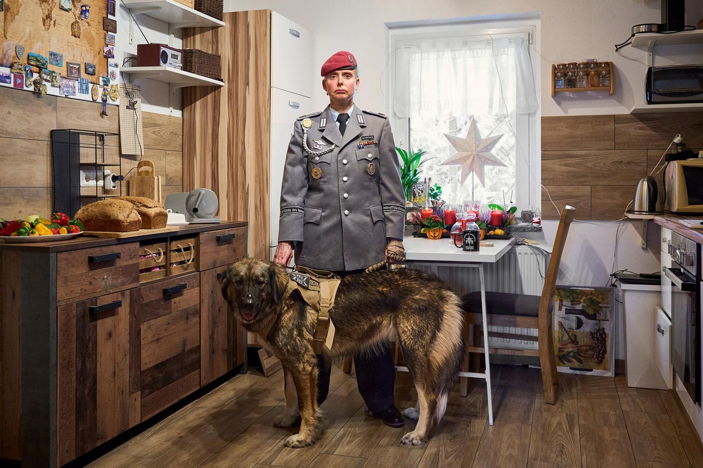 Ein Porträt von einer Frau in Uniform in ihrer Küche mit Hund