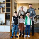 Ein Porträt von einer Familie zuhause. Der Vater ist in Uniform