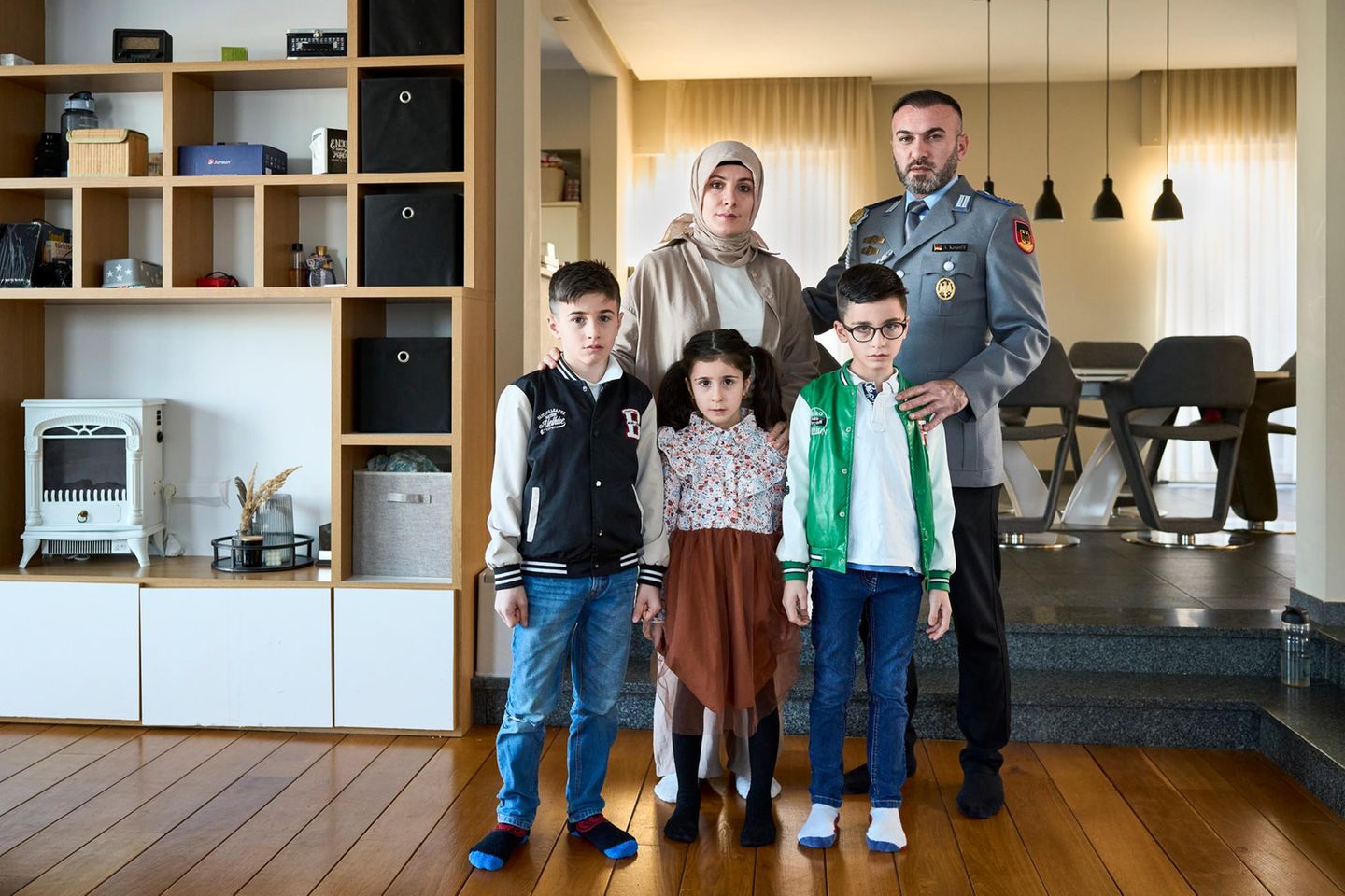 Ein Porträt von einer Familie zuhause. Der Vater ist in Uniform