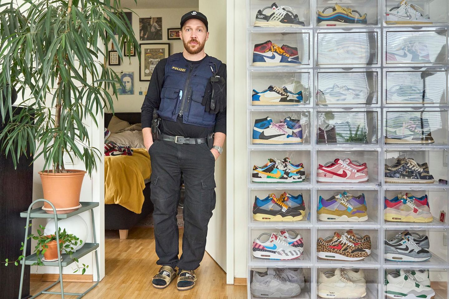 Ein Porträt von einem Mann in Uniform in seiner Wohnung mit Schuhsammlung