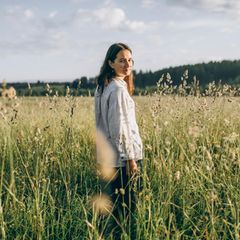 Eine Frau steht in einem Feld in der Natur