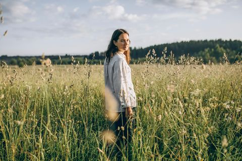Eine Frau steht in einem Feld in der Natur