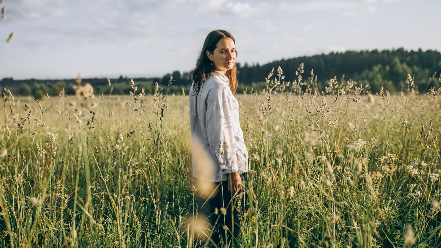 Eine Frau steht in einem Feld in der Natur