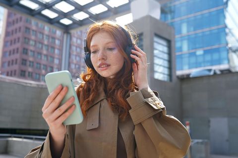 Junge Frau mit Smartphone nutzt Whatsapp