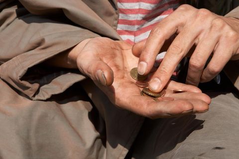 Empathie für die Bedürfnisse anderer: Ein Mann hält einige Münzen in seiner Hand