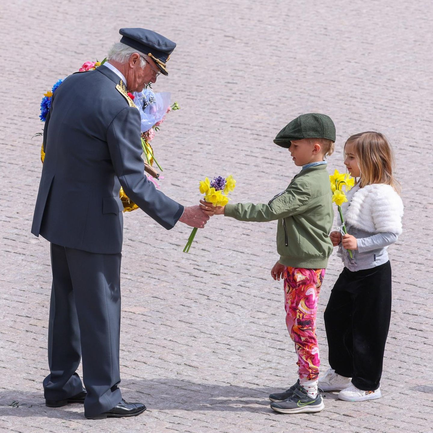 Stockholm, Schweden. Zahlreiche royale Gäste sowie Schaulustige sind nach Stockholm gekommen, um Schwedens König Carl XVI. Gustaf zu seinem 80. Geburtstag zu gratulieren. Darunter auch diese Kinder, die dem Monarchen am Königspalast Blumen überreichen