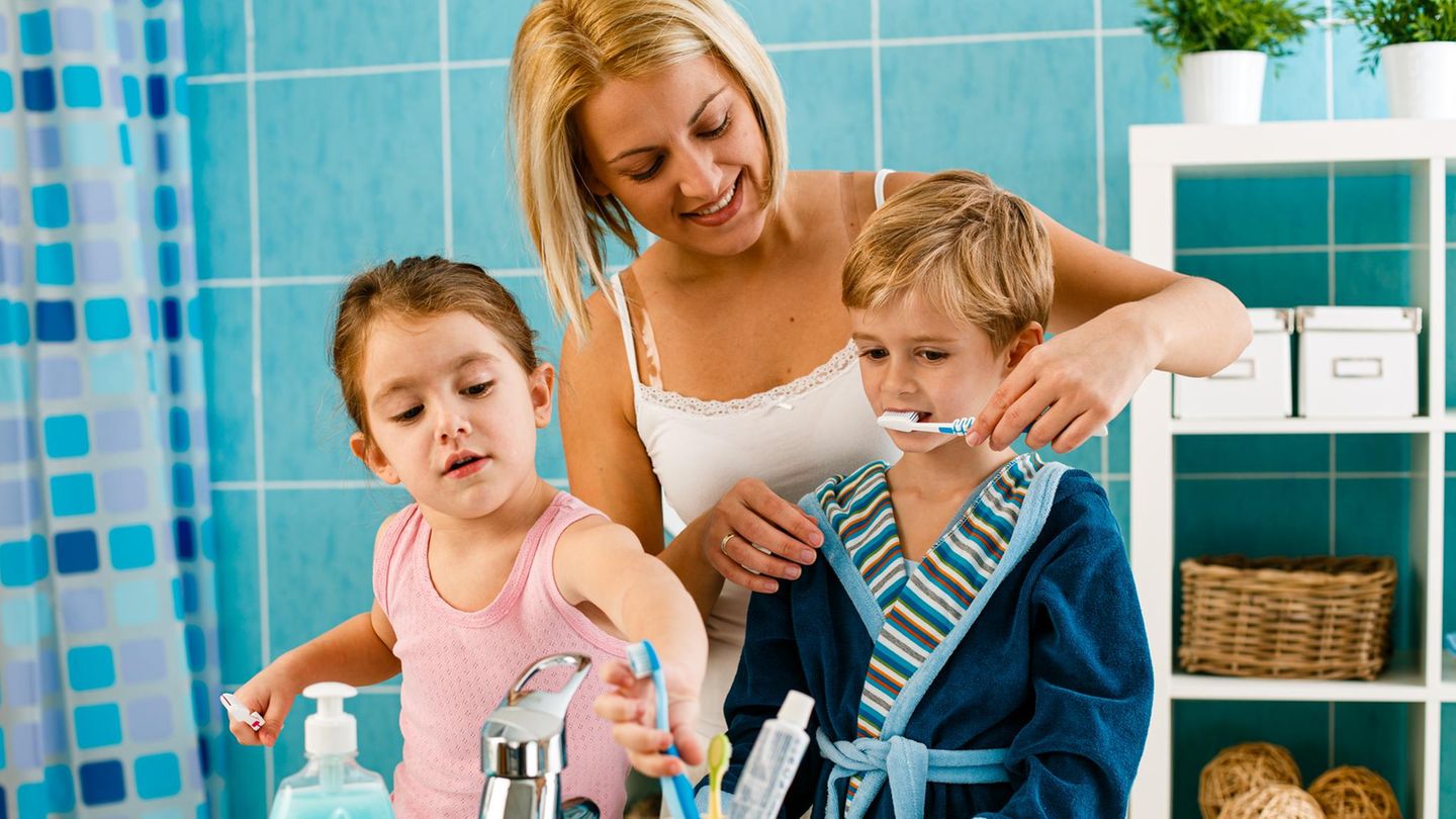 Eine Mutter putzt ihrem Sohn die Zähne