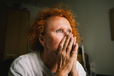 eine Frau schaut zweifelnd in die Ferne