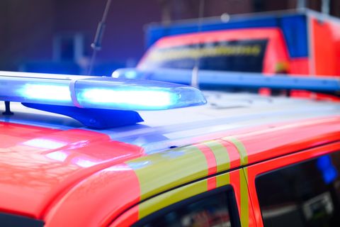 Ein PKW und ein Rettungswagen stehen mit Blaulicht hintereinander