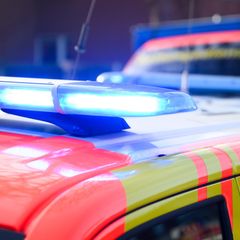 Ein PKW und ein Rettungswagen stehen mit Blaulicht hintereinander