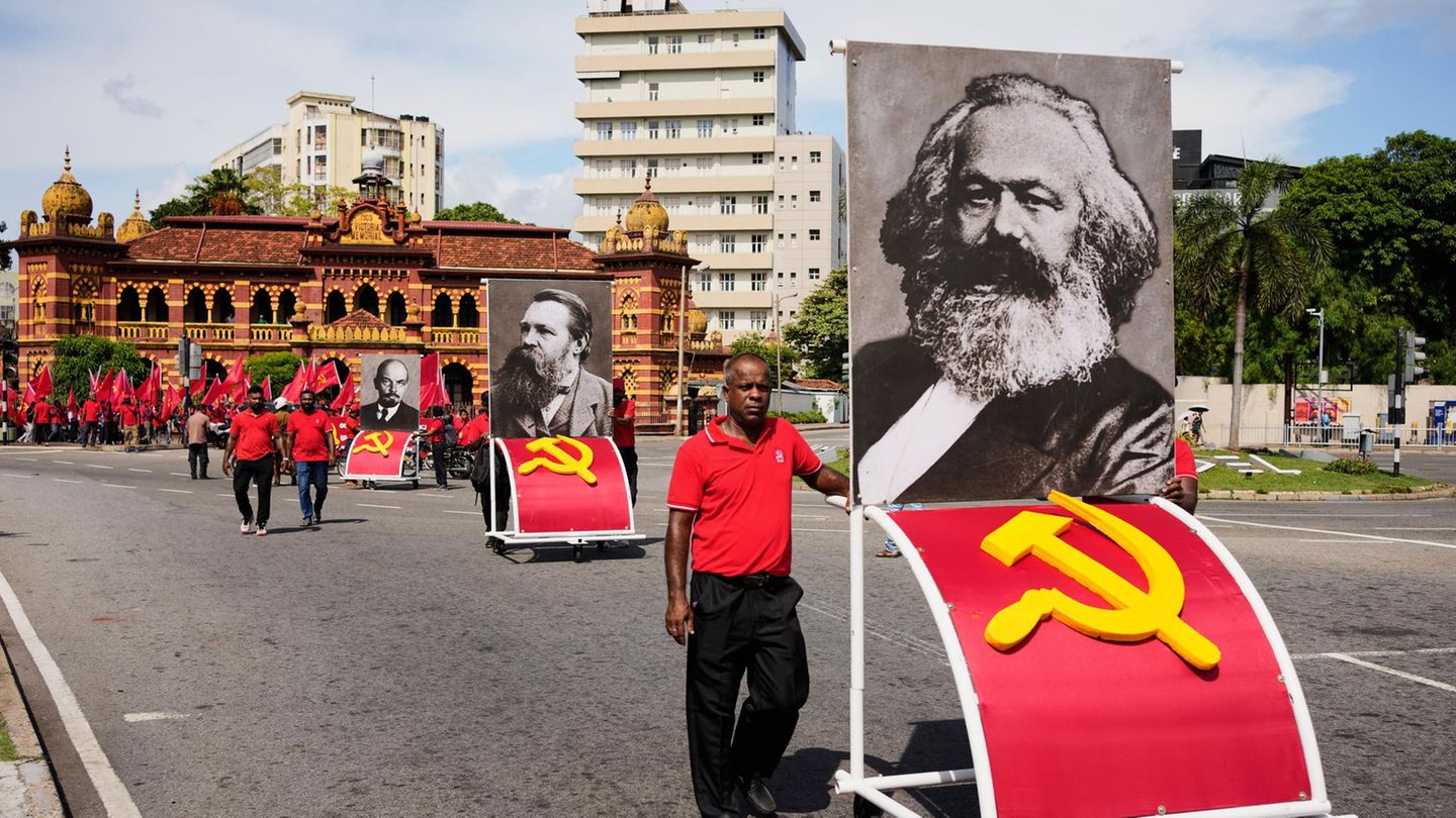 Colombo, Sri Lanka. Mitglieder der Frontline Socialist Party tragen Porträts der kommunistischen Persönlichkeiten Karl Marx, Friedrich Engels und Wladimir Lenin während eines Marsches zum Tag der Arbeit.
