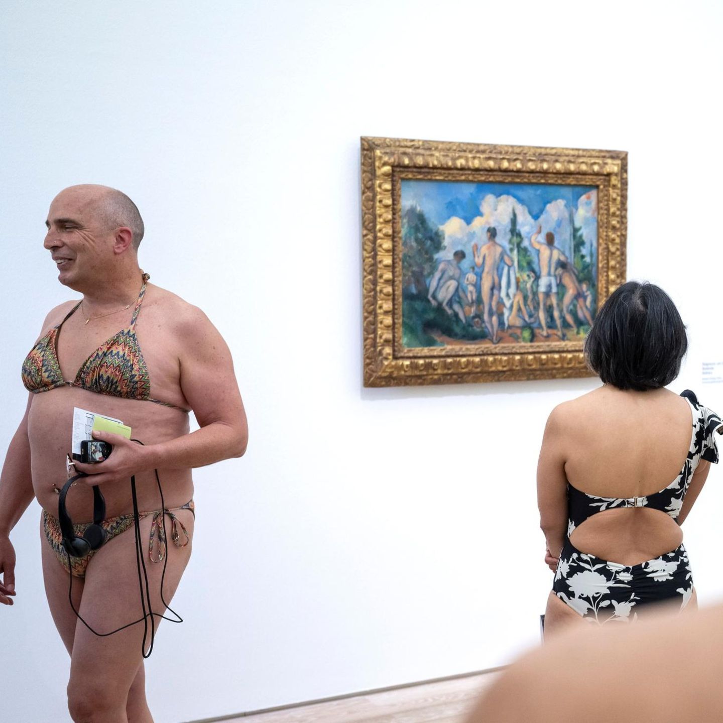 Riehen, Schweiz. Besucher in Badekleidung begutachten das Bild Badende von Paul Cezanne, bei der Ausstellung „Tag der Badenden“ in der Fondation Beyeler in Riehen. Alle Besucherinnen und Besucher, die in Badekleidung erschienen, erhielten Gratiseintritt.