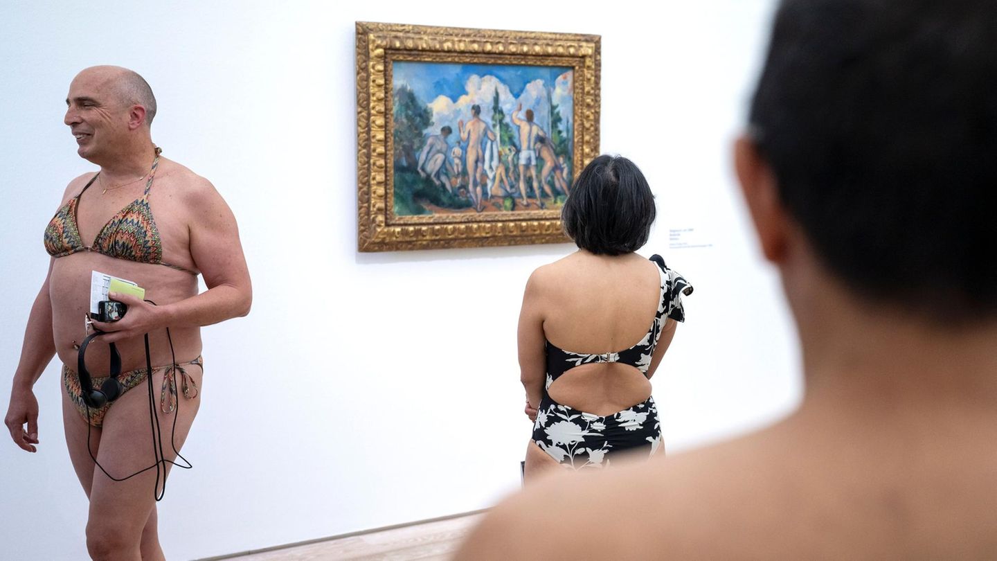Riehen, Schweiz. Besucher in Badekleidung begutachten das Bild Badende von Paul Cezanne, bei der Ausstellung „Tag der Badenden“ in der Fondation Beyeler in Riehen. Alle Besucherinnen und Besucher, die in Badekleidung erschienen, erhielten Gratiseintritt.