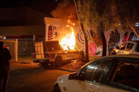 Ein Polizeifahrzeug brennt vor dem Krankenhaus in Alice Springs. Foto: Rhett Hammerton/AAP Image/AP/dpa