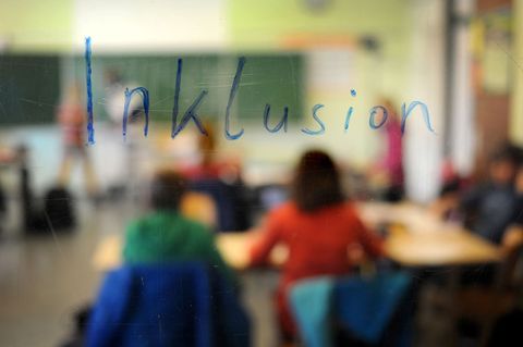 Schüler sitzen am in einer Inklusions-Klasse unter dem Schriftzug "Inklusion". (Symbolbild) Foto: Jonas Güttler/dpa