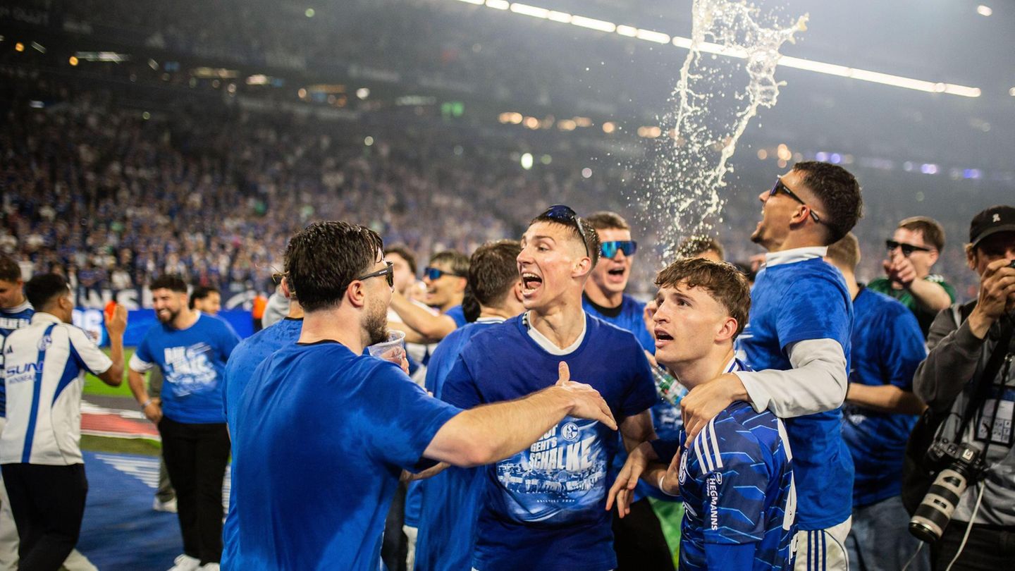 Das Team feiert mit einer Bierdusche auf dem Platz.