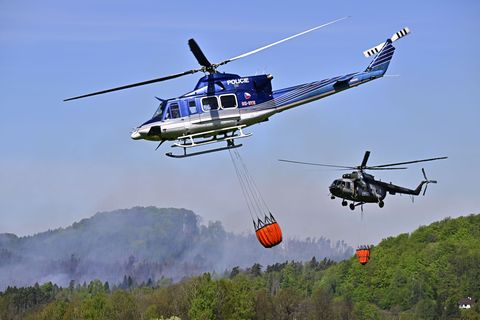 Hubschrauber fliegen mit Löschwasser-Behältern zu einem Waldbrand im Nationalpark Böhmische Schweiz. Foto: Hájek Ondøej/CTK/dpa