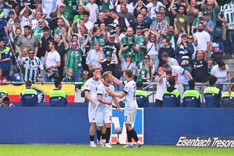Münsters Spieler bejubeln das Tor zum 3:3 in Hannover. Foto: Swen Pförtner/dpa