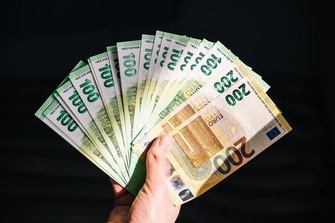 Eine Hand hält aufgefächerte Geldscheine
