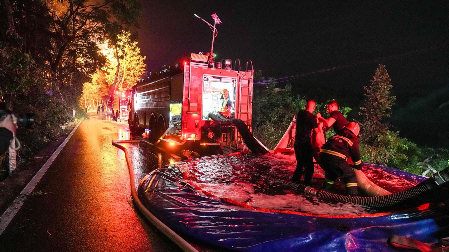 Guandu, China: Nach einer Explosion in einer Feuerwerksfabrik leuchtet das Feuer durch die Bäume im Hintergrund – als wäre es das Tor zur Hölle. Die Rettungskräfte haben auf jeden Fall viel zu tun.